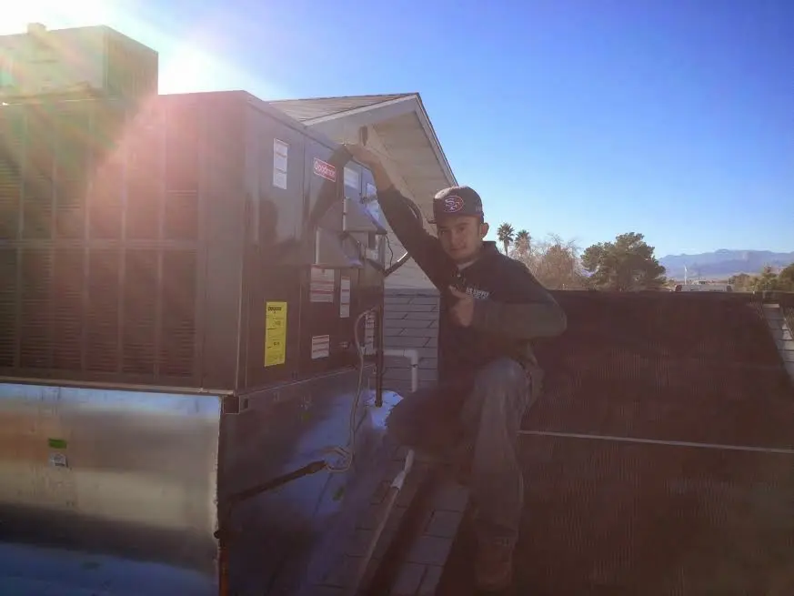 HVAC technician performing Air Duct Cleaning on a rooftop unit in Little Falls